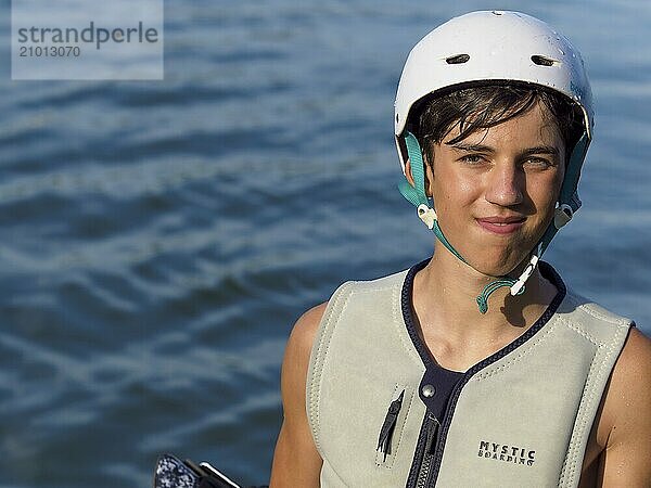 Sporty young man with helmet and waistcoat at the lake  portrait  water sports  water skiing in wakepark