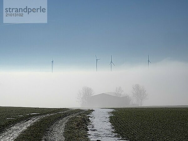 View from Thuringia over the foggy Saale valley to the wind turbines in Bavaria