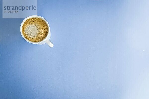 White cup of coffee on light blue background