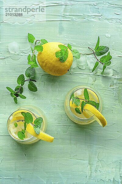 Lemonade with mint. Lemon water drink with ice. Two glasses on a blue background  overhead flat lay shot. Detox beverage. Fresh homemade cocktail  Food photography