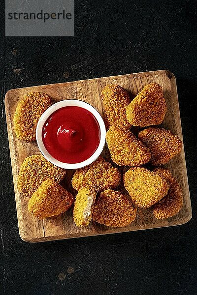 Chicken nuggets with ketchup on a dark background  shot from above with a place for text. A crispy appetizer at a restaurant  finger food  Food photography  Food photography