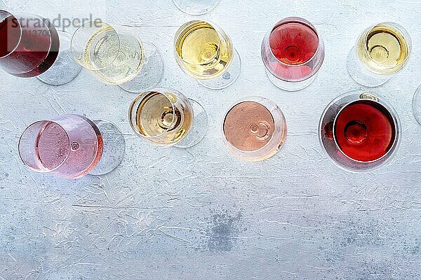 Wine glasses at a tasting. Rose  red  and white wine  drinks on a table at a winery  shot from above. An assortment of wines of many different colours