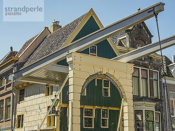 Historic bridge and building with green doors and brick under a blue sky  alkmaar  the netherlands