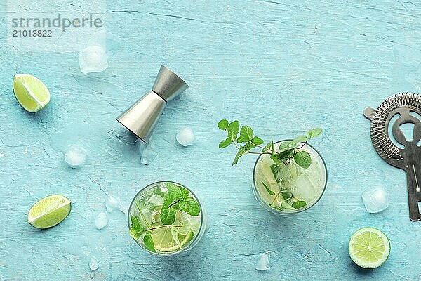 Mojito cocktail. Summer cold drink with lime  fresh mint  and ice. Cool beverage on a blue background  shot from the top with a place for text  Food photography  Food photography