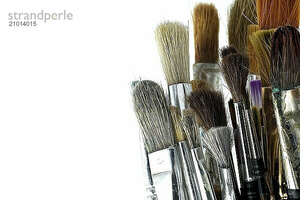 Array of paintbrushes of different sizes and colors isolated on white background