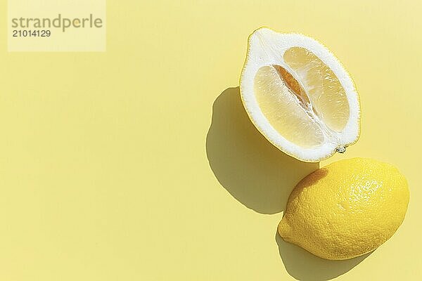 Two halved cuts of lemon with shadow on yellow background. Healthy eating  travel or vacation concept