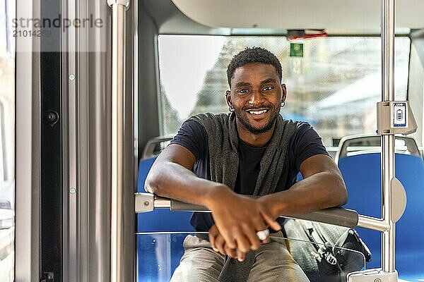 Portrait of a happy african man sitting on the public bus on the way to work