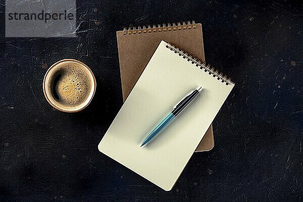 Notebook mockup with a pen and a cup of coffee  overhead flat lay shot on a dark background  Food photography