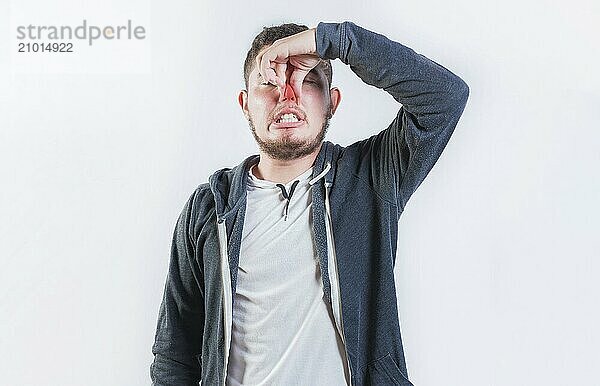 Guy suffering with nasal bridge on isolated background. Suffering man with nasal bridge pain isolated