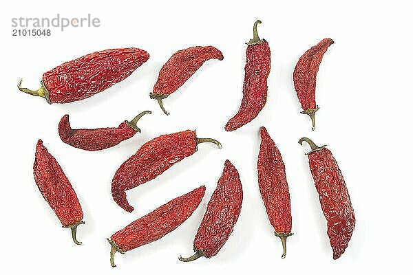 A flat lay studio photo of partially drying red peppers set on a white background