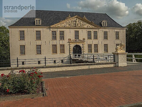 Manor house in historical style  in the foreground flower beds and a decorated bridge  dornum  east frisia  germany