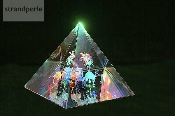 Glowing glass pyramid on dark background