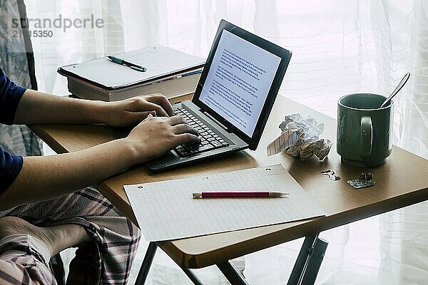 A lifestyle photo of a girl using the notebook computer at home to do homework