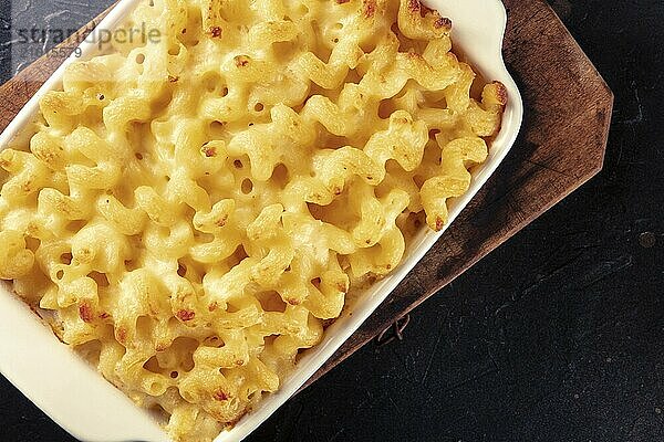 Macaroni and cheese pasta in a casserole  shot from the top on a black background with a place for text  Food photography  Food photography