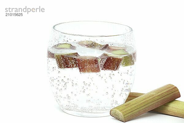 Transparent glass filled with cold water and several pieces of rhubarb isolated on white background