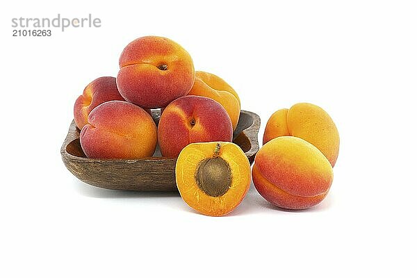 Group of fresh whole apricots and one cut in half to reveal its interior  isolated on a white background