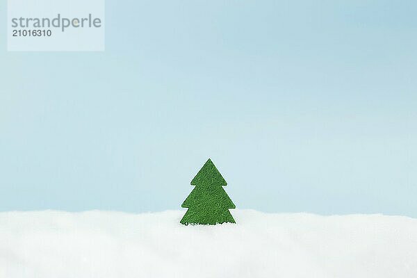 Green christmas tree on blue background with fake snow