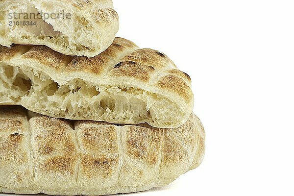 Pieces of pita flat-bread are stacked atop each other isolated on white background with free copy space  typical fast food item  with the potential to be used as a snack