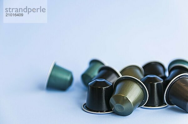 Beautiful colored coffee capsules on light blue background