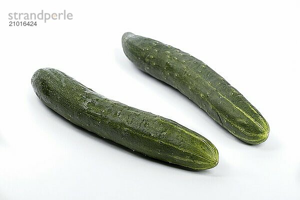 A close up studio photo of two whole cucumbers set on a white background