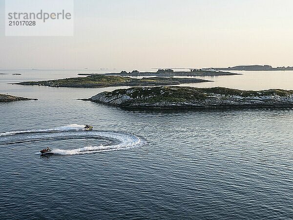 Two jet skis cruise through the Norwegian archipelago