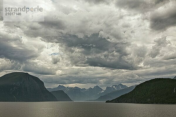 Mountains along the Romsdalsfjorden near Andalsnes under a cloudy sky  Norway  Europe