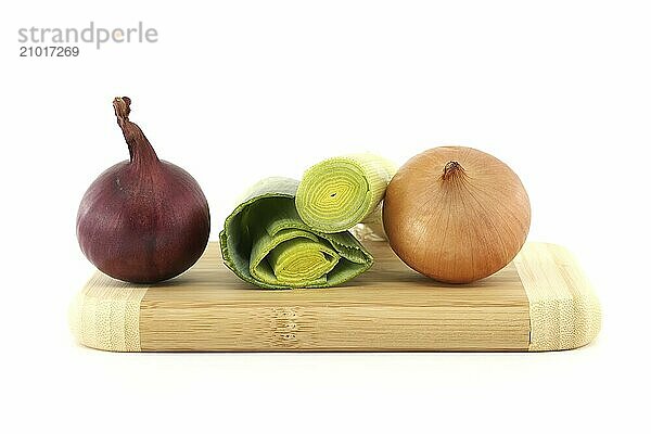 Sliced green leek between red and yellow onions isolated on white background