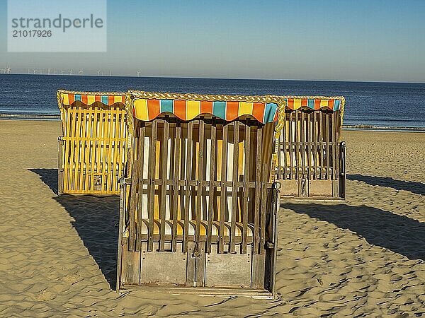 Several beach chairs stand on the sandy beach overlooking the calm sea on a clear  sunny day  egmond aan zee  the netherlands