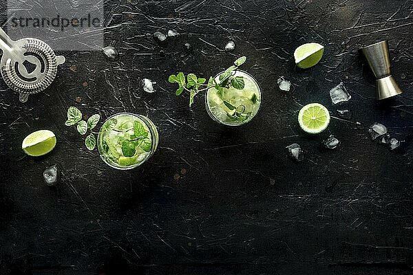 Mojito cocktail. Summer cold drink with lime  fresh mint  and ice. Cool beverage on a black background  shot from above with a place for text  Food photography  Food photography