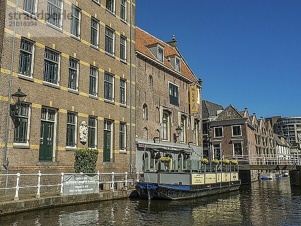 Museum in a brick building on the canal with a boat and flower boxes in the foreground  alkmaar  the netherlands