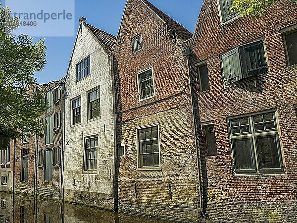 Group of old brick buildings next to a canal in sunny weather  alkmaar  the netherlands