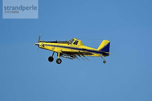 A small crop duster is flying in the sky near Spangle  Washington