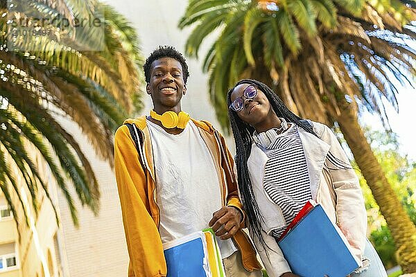 Low angle view portrait of two african american students smiling proud in the campus