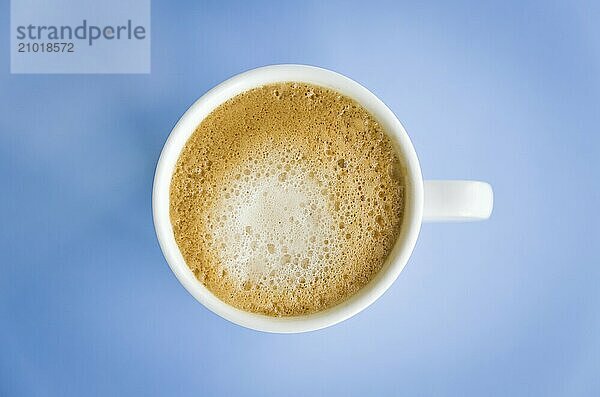 White cup of coffee on light blue background