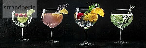 Fancy cocktails with fresh fruit panorama. Gin and tonic drinks with ice at a party  on a black background  a panoramic banner