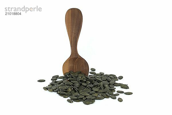 Raw pumpkin seeds or pepitas shelled in wooden spoon  isolated on white background