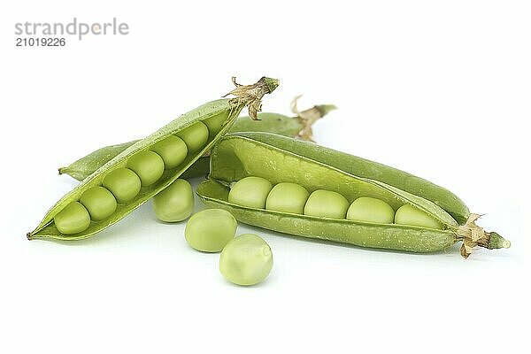 Close-up of a pea pod and a few peas isolated on a white background. Pea pod is open and reveals several small  round green peas inside