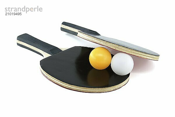 Isolated on a white background are two ping pong paddles and a ping pong ball  with one racket's surface appearing in red and the other in black