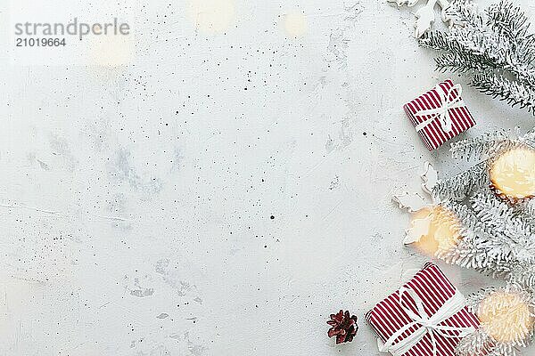 Christmas  New Year gray concrete flat lay. Red white striped present gift boxes top view. Gift ribbon and packaging paper. Christmas tree fir  cones  toy balls  wooden star. Copy space area on photo