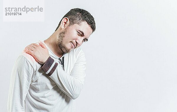 Person with shoulder muscle pain on isolated background. Unhappy man with shoulder pain isolated