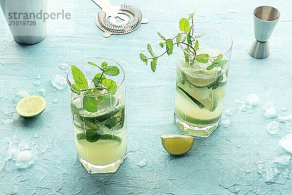 Mojito cocktail  two glasses. Summer cold drink with lime  fresh mint  and ice. Cool beverage on a blue background  Food photography