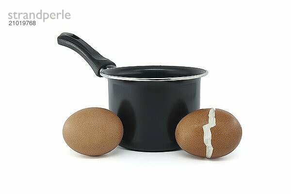 Black cooking pot and a batch of hard-boiled eggs  one of which broke during the boiling process  isolated on a white background