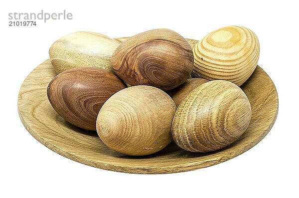 Hand-turned wooden eggs in a small wooden bowl painted on white