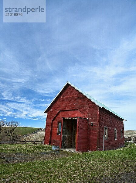 A red barn sits underneath a cloudy sky in the Palouse area of Washington