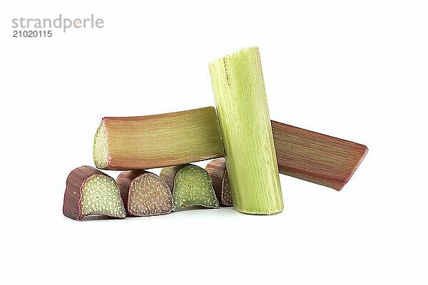 Group of rhubarb pieces in various shapes and sizes arranged in a scattered formation isolated on white background