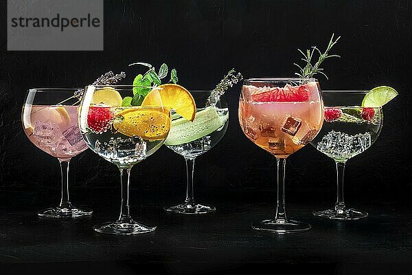 Fancy cocktails with fresh fruit. Gin and tonic drinks with ice at a party  on a black background  a variety