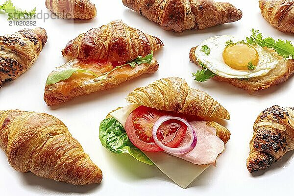 Croissant sandwich assortment. Various stuffed croissants on a white background. Rolls filled with ham  salmon  egg  etc  Food photography