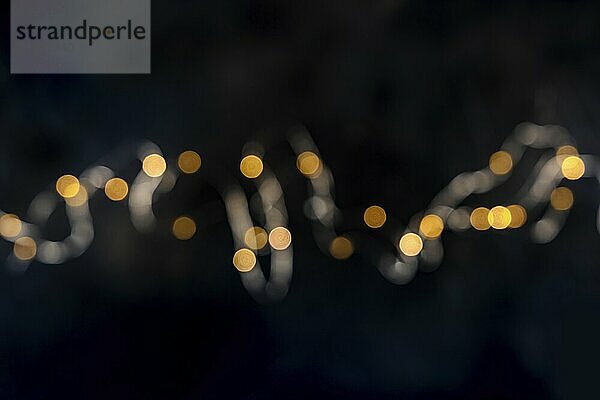 Fairy lights  string led garland  blurred  shot from above with bokeh on a black background. Abstract festive banner with copy space  Food photography