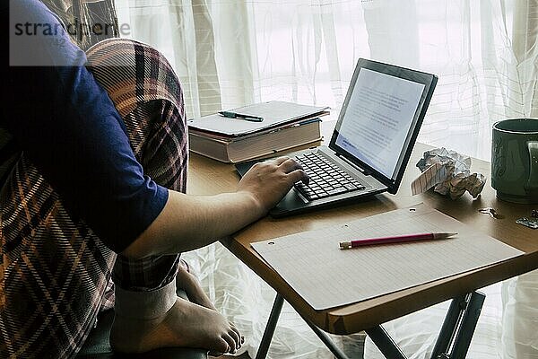 A lifestyle photo of a girl using the notebook computer at home to do homework