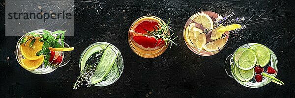 Fancy cocktails with fresh fruit panorama. Gin and tonic drinks with ice at a party  on a black background  panoramic banner  overhead flat lay shot  Food photography  Food photography